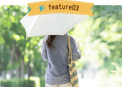 遊歩道の中で日傘を差して歩く女性